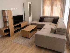 a living room with a couch and a tv at Cozy Apartment Astiri in Tirana