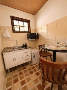 a kitchen with a table and chairs and a sink at Chalés do Lago Lumiar in Nova Friburgo