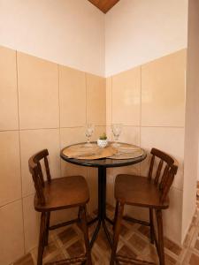 a table with two chairs and two wine glasses on it at Chalés do Lago Lumiar in Nova Friburgo