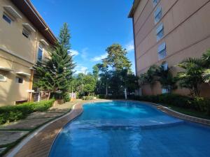 a swimming pool in front of a building at Spacious Studio w Pool, Gym, Smart Lock, Netflix in Puerto Princesa City
