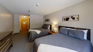 a hotel room with two beds and a desk at Inn at Snowshoe in Snowshoe