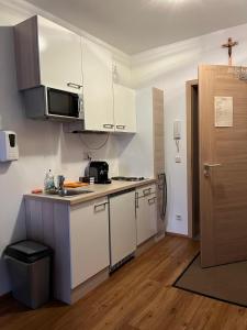 a kitchen with white cabinets and a counter top at Ferienwohnungen Gruber in Rust +7 photos