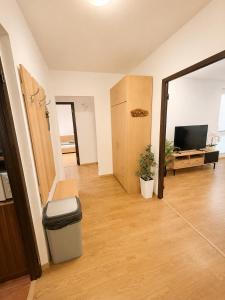 a living room with a trash can and a television at Apartnám Harmony in Martin +1 photo