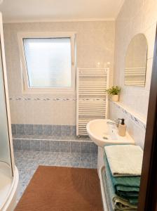 a white bathroom with a sink and a window at Apartnám Harmony in Martin