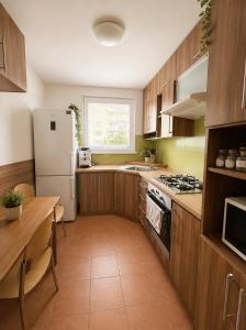 a kitchen with wooden cabinets and a white refrigerator at Apartnám Harmony in Martin