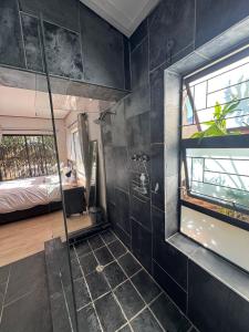 a bathroom with a glass shower and a bedroom at Hidden Gem in George