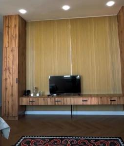 a flat screen tv sitting on top of a wooden table at Caspian Deluxe Apart Hotel in Aktau +12 photos