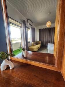 a mirror reflection of a room with a bed and a couch at Tropical Breeze Apartments in Paramaribo