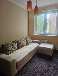 a living room with a couch and a window at Apartament Merkury in Koszalin