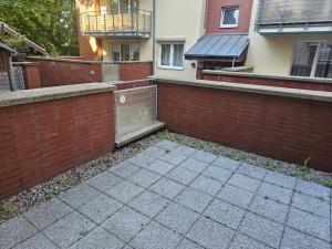 a brick wall and a sidewalk in front of a building at Apartament Merkury in Koszalin