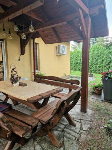 a wooden picnic table and chairs on a patio at Lawendowa Ostoja - dom na wyłączność in Uście