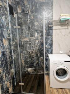 a bathroom with a shower and a washing machine at Lawendowa Ostoja - dom na wyłączność in Uście +11 photos