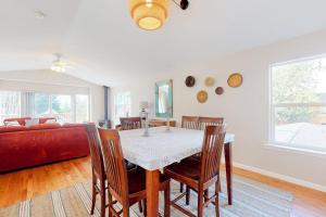 a dining room with a table and a red couch at True North in Rockaway Beach