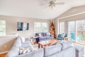 a living room with two couches and a ceiling fan at True North in Rockaway Beach