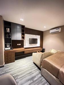 a bedroom with a bed and a flat screen tv at Calia in Lagos