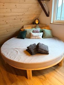 a large bed in a room with a wooden wall at Gästeappartements Mechels in Wilnsdorf