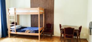 a bunk bed in a room with a table and chairs at Vintageshvili hostel and guest house in Tbilisi City
