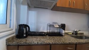 a kitchen counter with a tea kettle on a counter top at Apart Plaza Escobar in Belén de Escobar