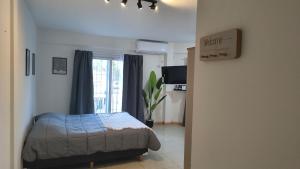 a bedroom with a bed and a window at Apart Plaza Escobar in Belén de Escobar