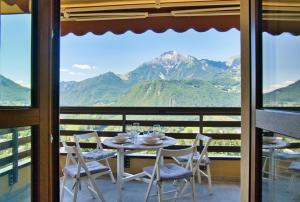 a table and chairs on a balcony with a view of mountains at Renzo e Lucia - la Terrazza Panoramica in Barzio