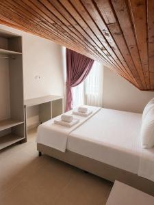 a bedroom with a large bed with a wooden ceiling at The Selection Butik Otel in Kemer