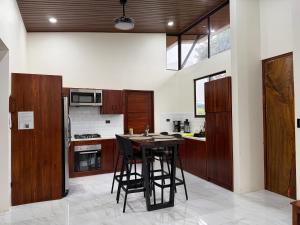 a kitchen with wooden cabinets and a table with chairs at Pies descalzos in Upala +5 photos