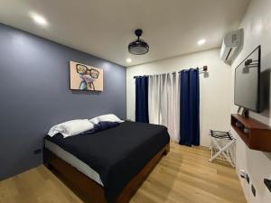 a bedroom with a bed and a flat screen tv at Pies descalzos in Upala