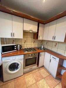 a kitchen with a stove and a microwave at Klaipeda City in Klaipėda +10 photos