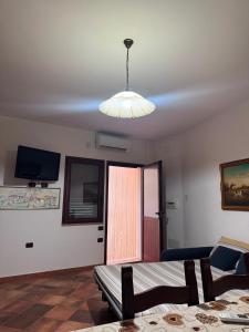 ein Zimmer mit einem Tisch und einer von der Decke hängenden Lampe in der Unterkunft Maison Marcel in Galtellì