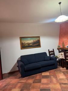 ein Wohnzimmer mit einem blauen Sofa und einem Tisch in der Unterkunft Maison Marcel in Galtellì