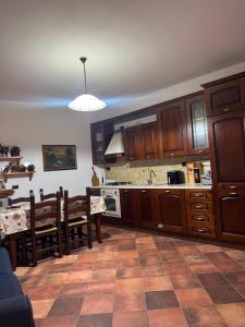eine Küche mit Holzschränken und einem Tisch sowie ein Esszimmer in der Unterkunft Maison Marcel in Galtellì