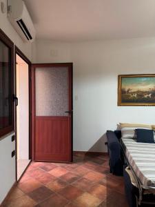 ein Zimmer mit einem Bett und einer roten Tür in der Unterkunft Maison Marcel in Galtellì