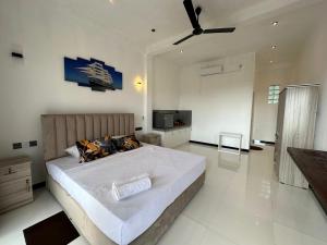 a bedroom with a large bed with a ceiling fan at Cinnamon Ridge Unawatuna in Unawatuna