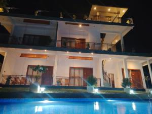 a villa with a swimming pool at night at Cinnamon Ridge Unawatuna in Unawatuna +8 photos