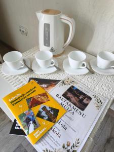 a table with two magazines and a tea pot and a book at Baltakmeņu muiža in Mujani +20 photos