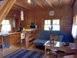 a living room with a blue couch in a log cabin at Chatki Saturnina i pokoje in Świnoujście