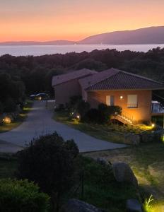 a house with a sunset in the background at Sarl Valinco Locations in Olmeto