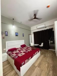 a bedroom with a bed and a table and a ceiling at Zen Studio Paramount in Greater Noida