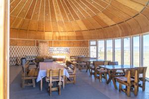 a restaurant with tables and chairs and a large ceiling at Yurt Camp "Sary-Bulun" at Song-Kul Lake, Naryn Сон-Куль in Song-Kul