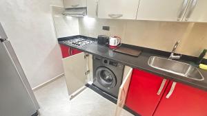 a small kitchen with a stove and a washing machine at Appartement Agadir Tilila 1 pour couples mariés et familles in Agadir