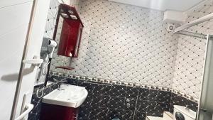 a bathroom with a black and white tiled wall at Appartement Agadir Tilila 1 pour couples mariés et familles in Agadir +3 photos