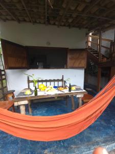 a hammock in front of a house with food on it at Casa de Deli in Ilha de Boipeba +41 photos