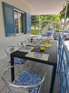 a dining table and chairs on a patio at Zoya's house in Nea Kallikrateia