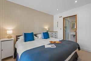 a bedroom with a large bed with blue pillows at House 34 in Looe +24 photos