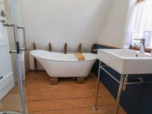 a bathroom with a bath tub and a sink at 1 Fountain Cottages in Tarporley +35 photos