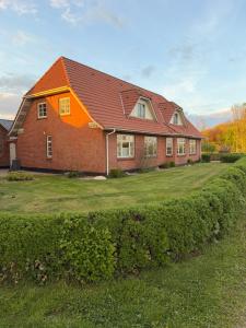 a red brick house with an orange roof at Vestergård Gæstehus in Varde