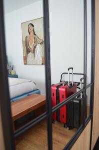 a room with a bed and two pieces of luggage at Apartman Vera in Prijedor