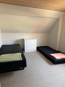 a bedroom with two beds and a dresser at Vestergård Gæstehus in Varde