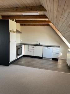 a large kitchen with white cabinets and a ceiling at Vestergård Gæstehus in Varde