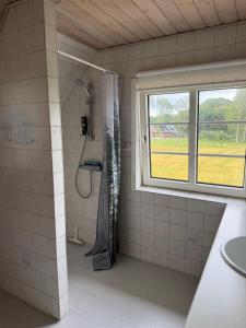 a bathroom with a shower and a window at Vestergård Gæstehus in Varde